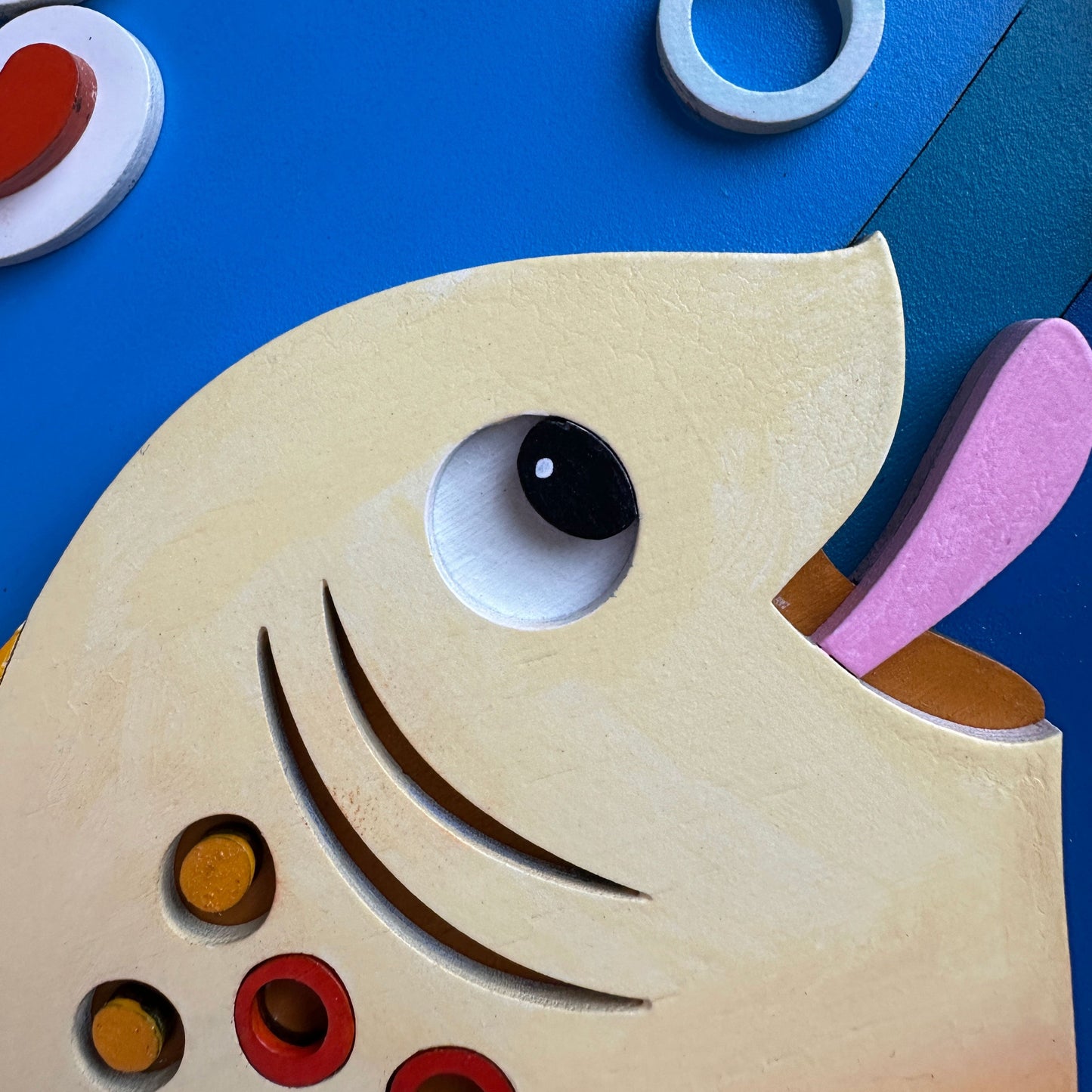 Wooden toy with a fish design on a blue background