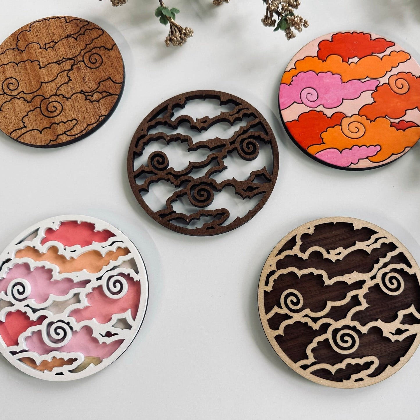 Five decorative coasters with unique patterns on a light background