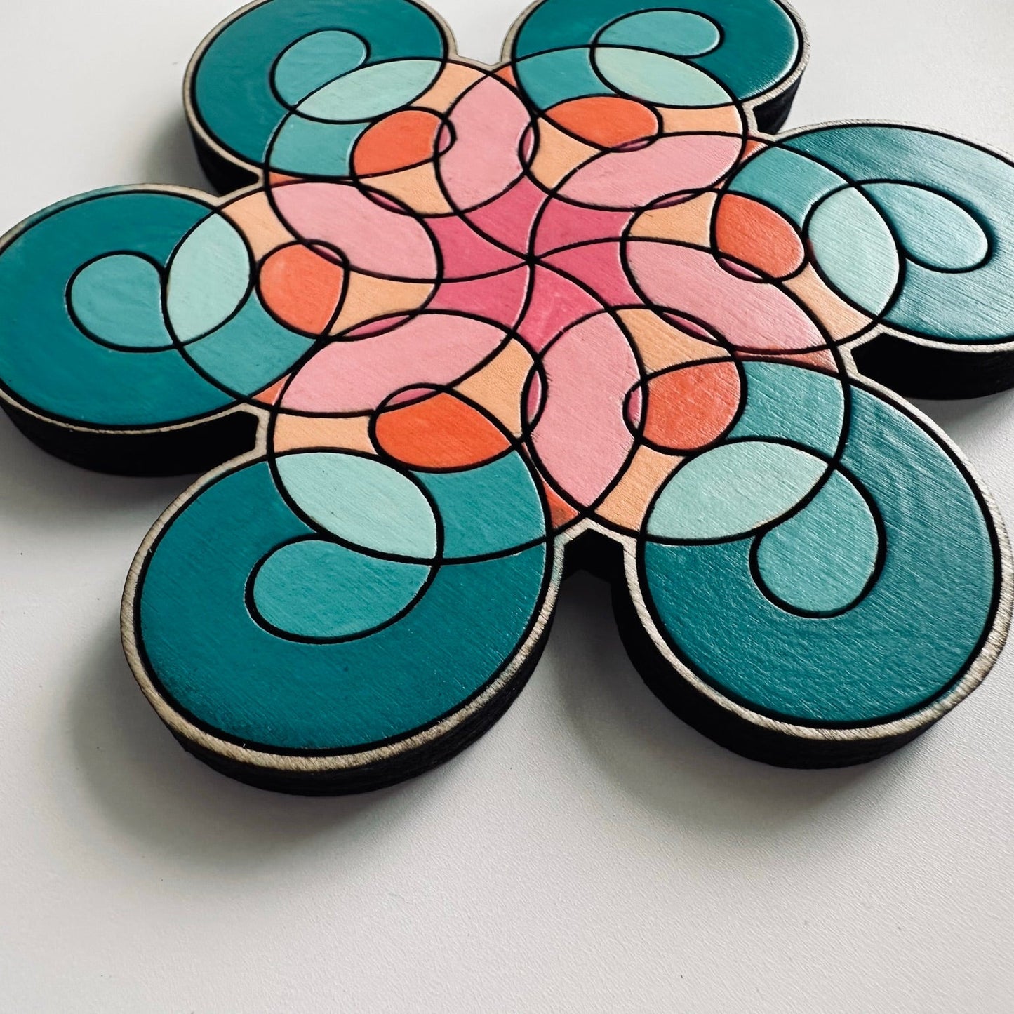 Colorful flower-shaped wooden coaster on a light gray background