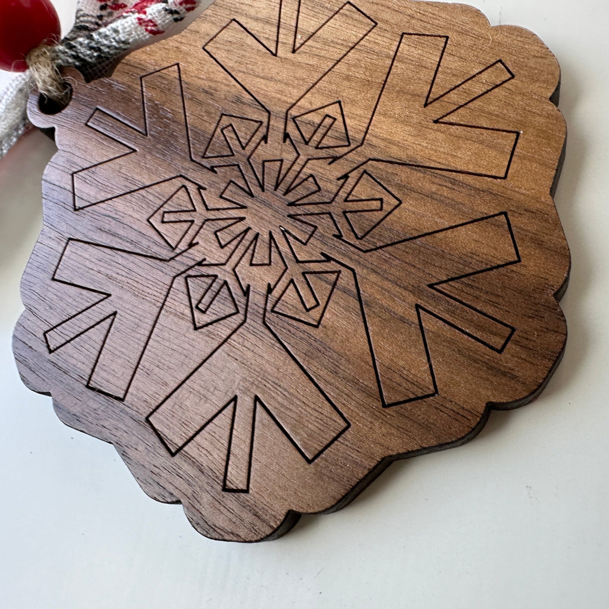 Wooden snowflake ornament with geometric design on a white background