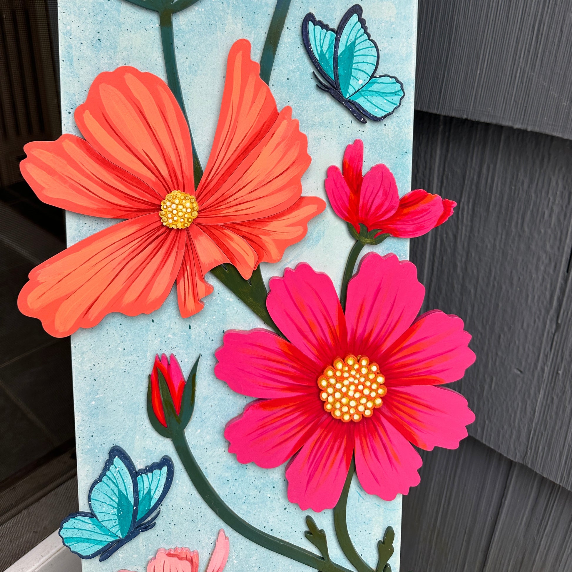 Decorative sign with flowers and butterflies on a textured surface