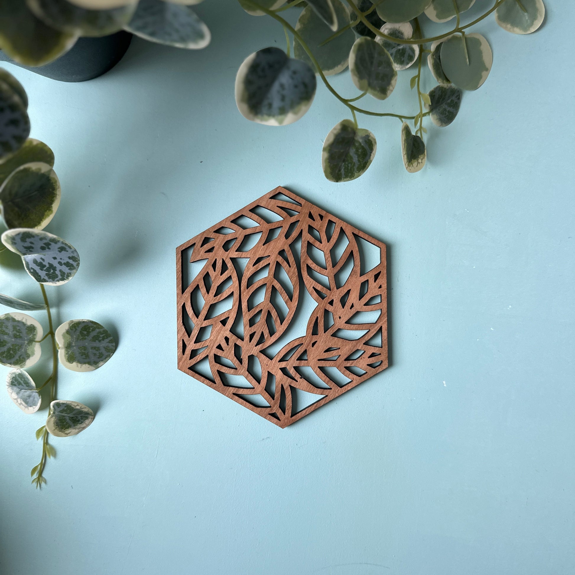 A decorative trivet with a leave design on a blue background