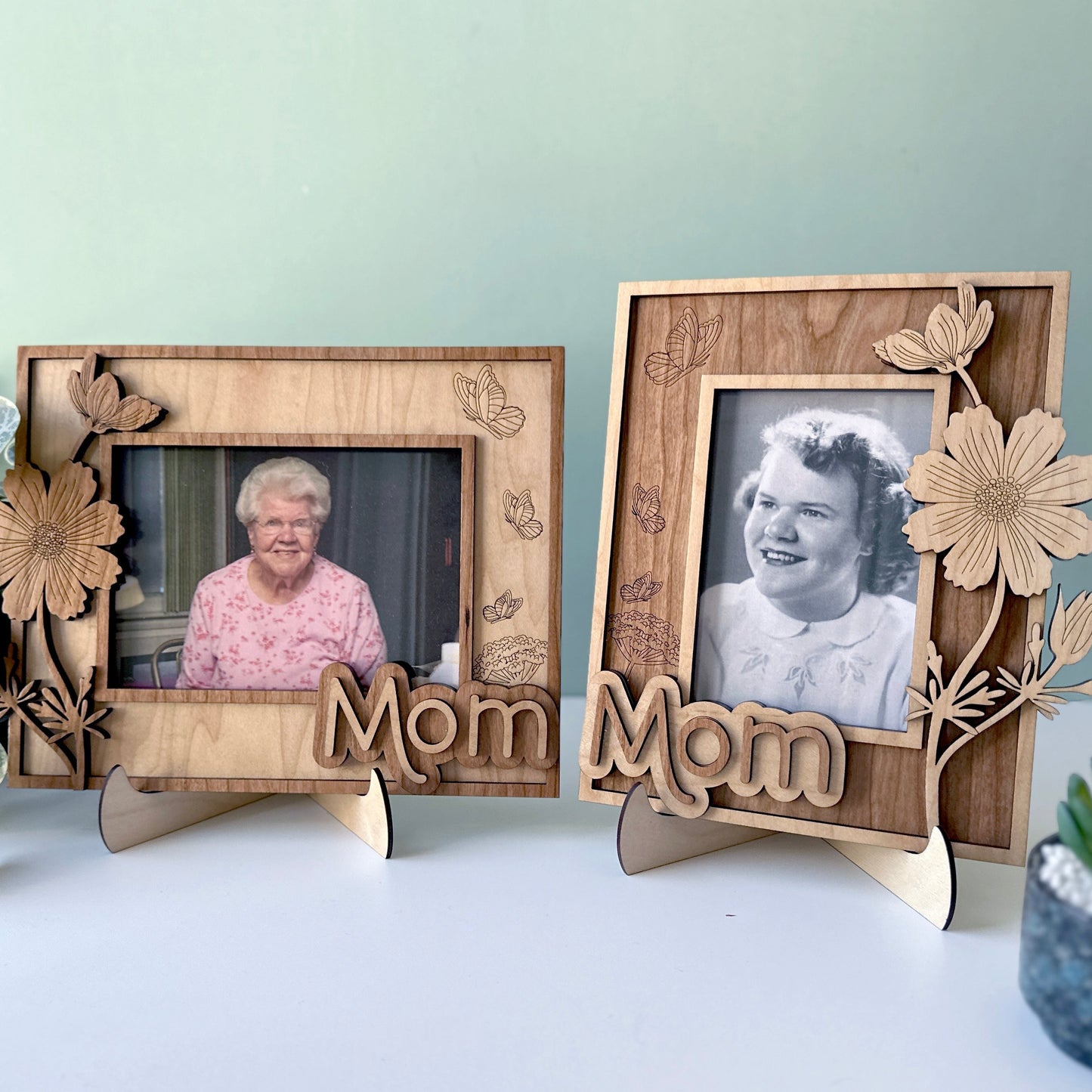 Two wooden photo frames with floral designs and 'Mom' text, displaying black and white photos of an elderly woman.