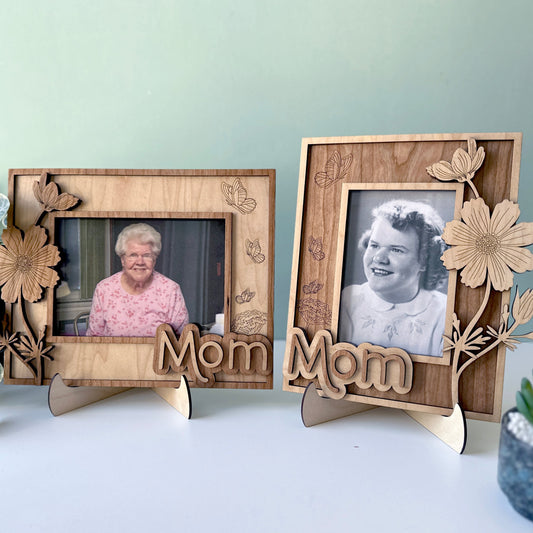 Two wooden photo frames with floral designs and 'Mom' text, displaying black and white photos of an elderly woman.