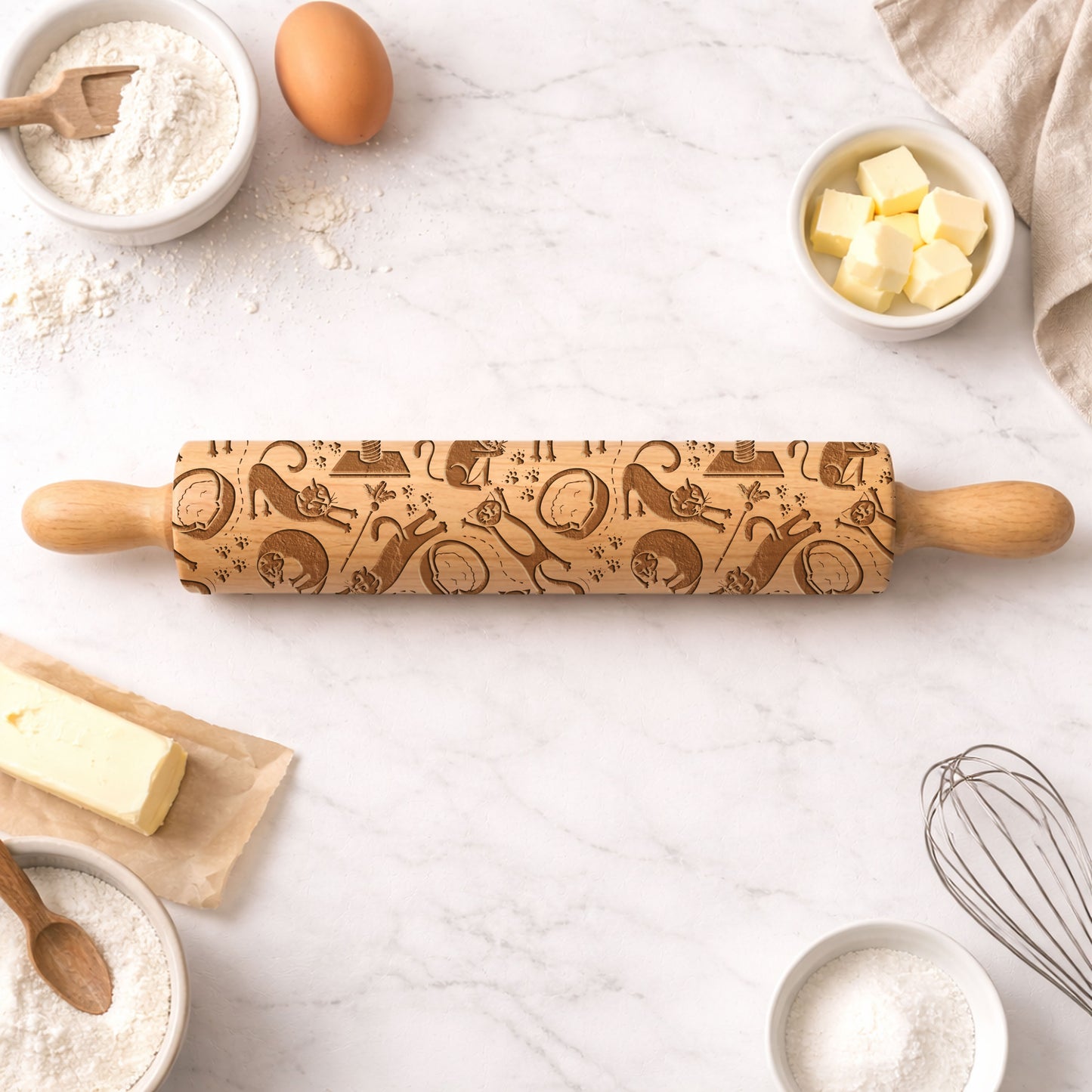 Wooden rolling pin with engraved patterns on a kitchen counter with baking ingredients.
