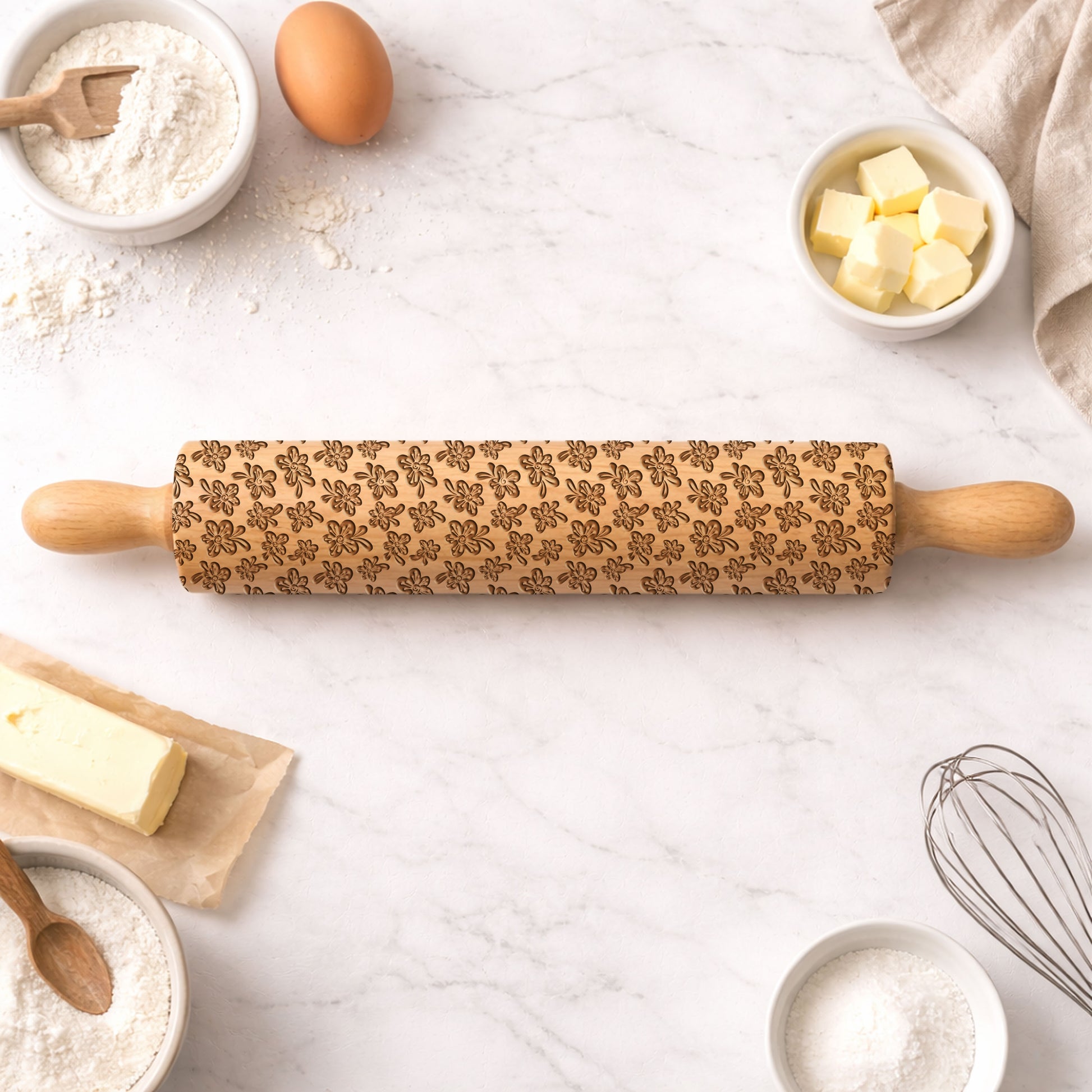 Wooden rolling pin with embossed pattern on a kitchen counter with baking ingredients.