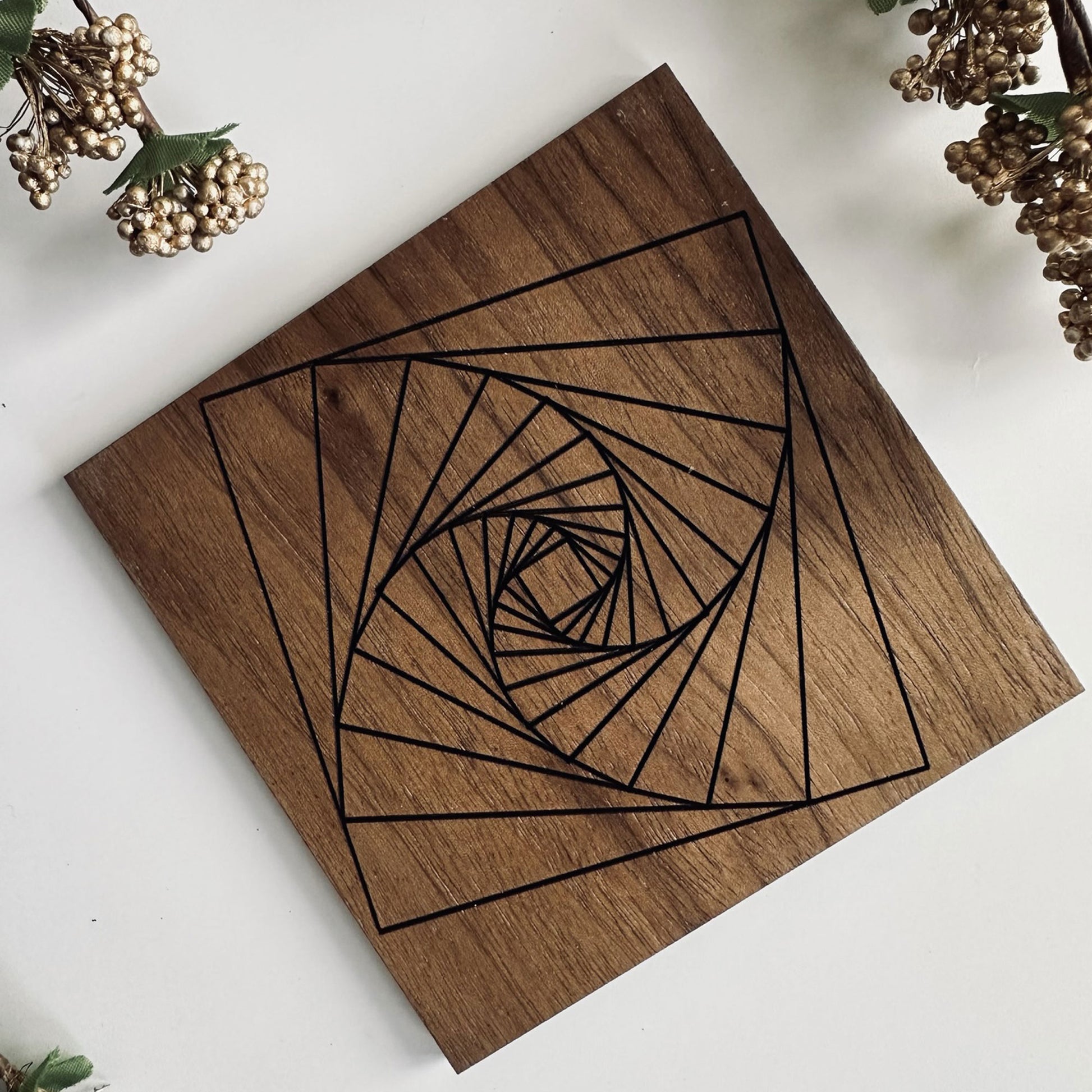 Wooden coaster with geometric spiral design on a white background