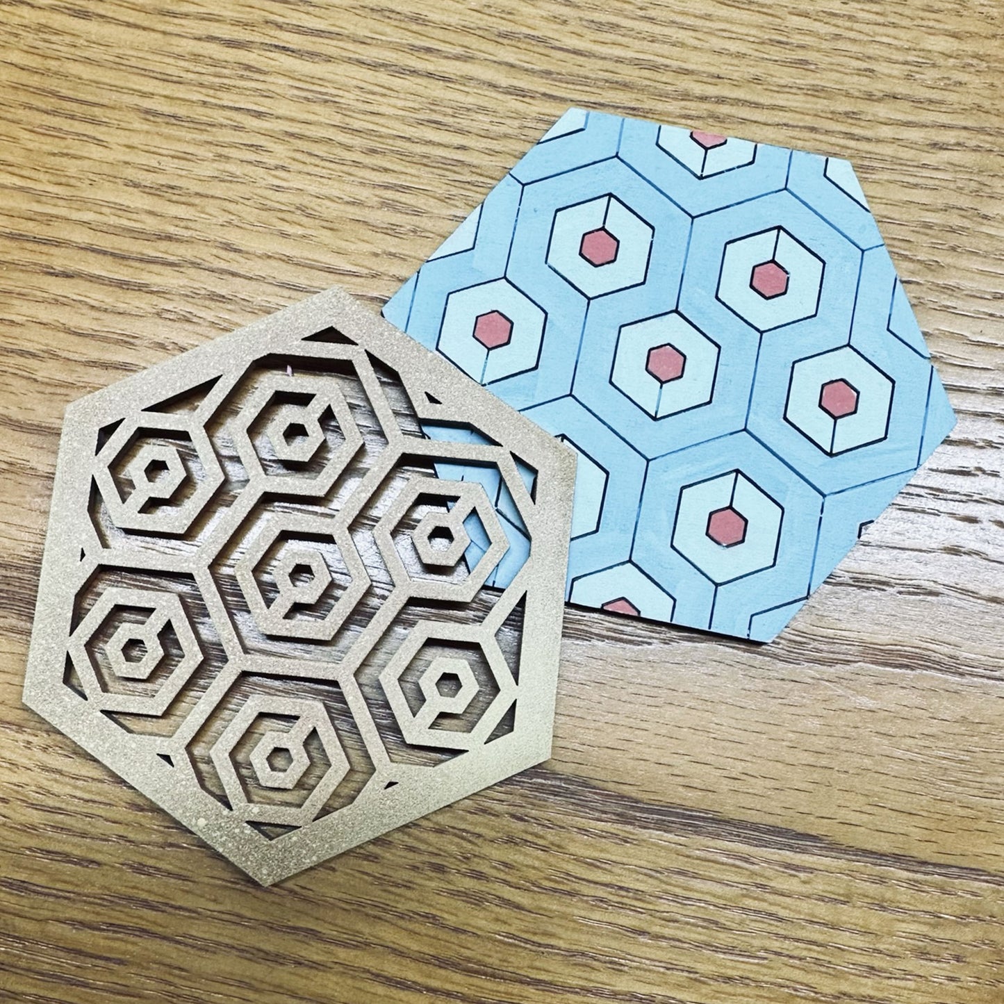 Two parts of a multi-layered coaster with a hexagonal pattern on it ready to be glued.