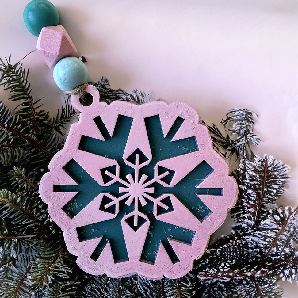 Decorative snowflake ornament on a branch with a white background