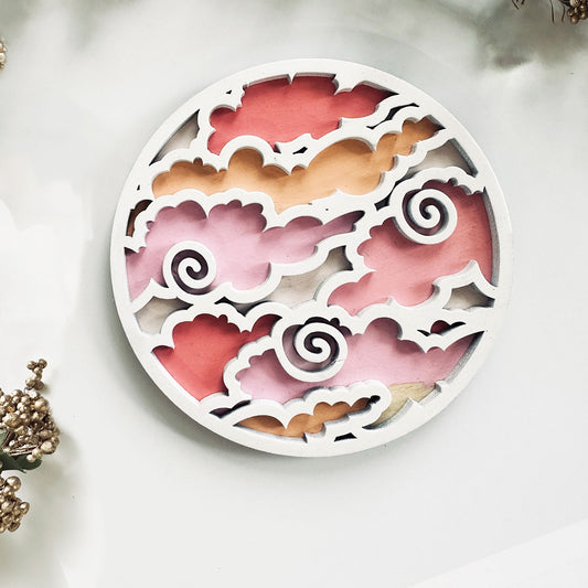 Decorative coaster with cut-out floral design on a white background
