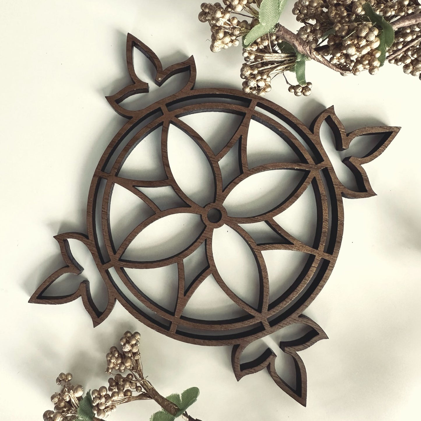 Decorative wooden coaster with intricate patterns on a light background