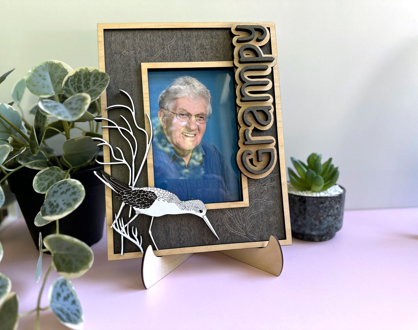 Photo frame with 'Grampy' text and a photo of an elderly man, surrounded by plants.