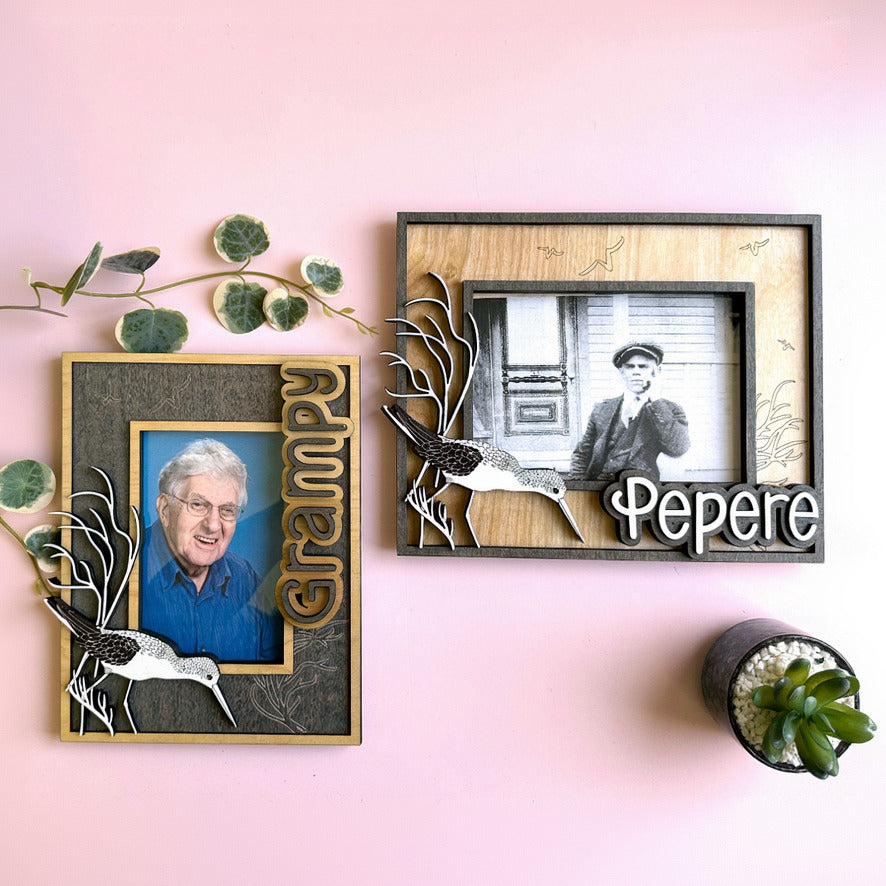 Two framed photographs on a pink wall with decorative elements.