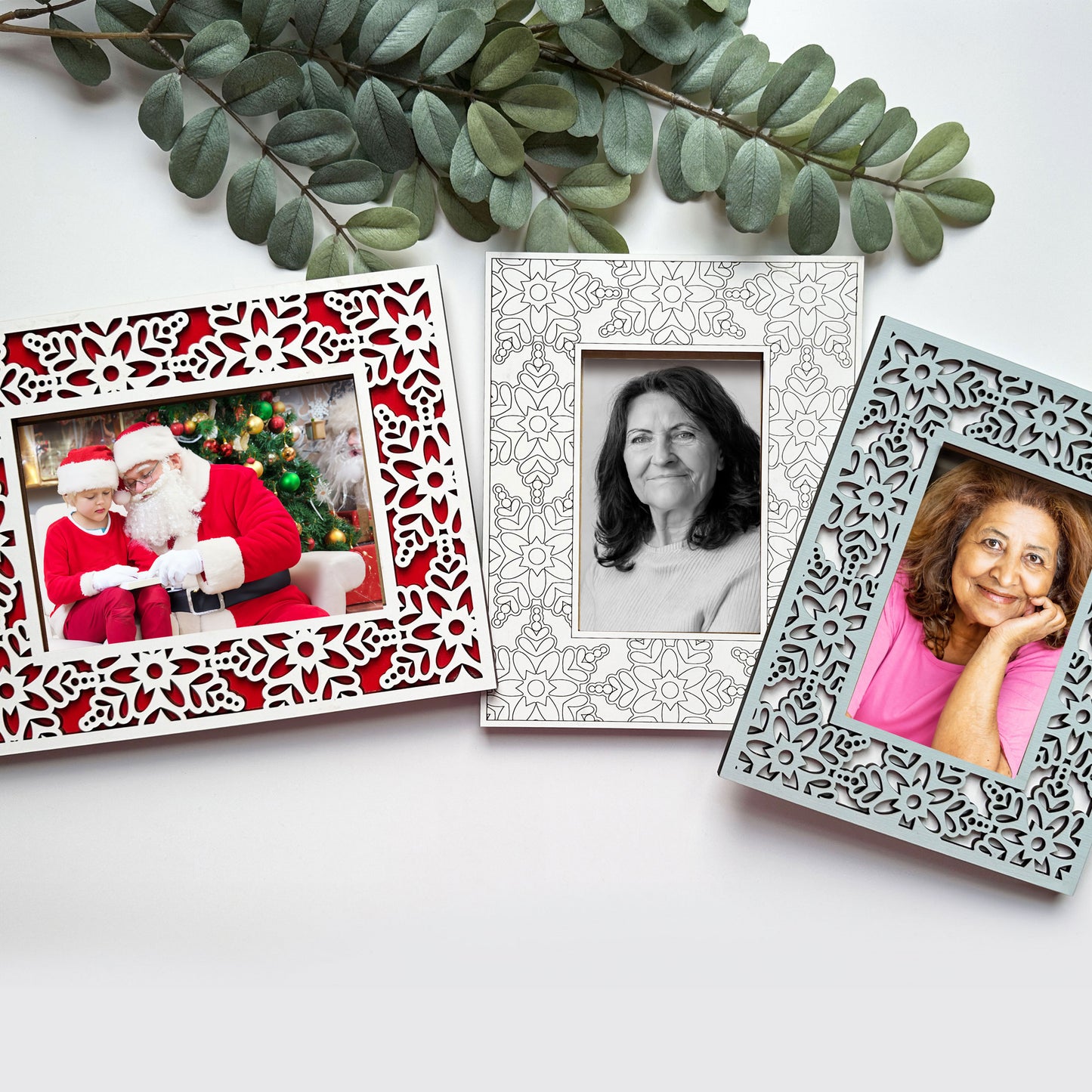 Three decorative photo frames with different images on a white surface.