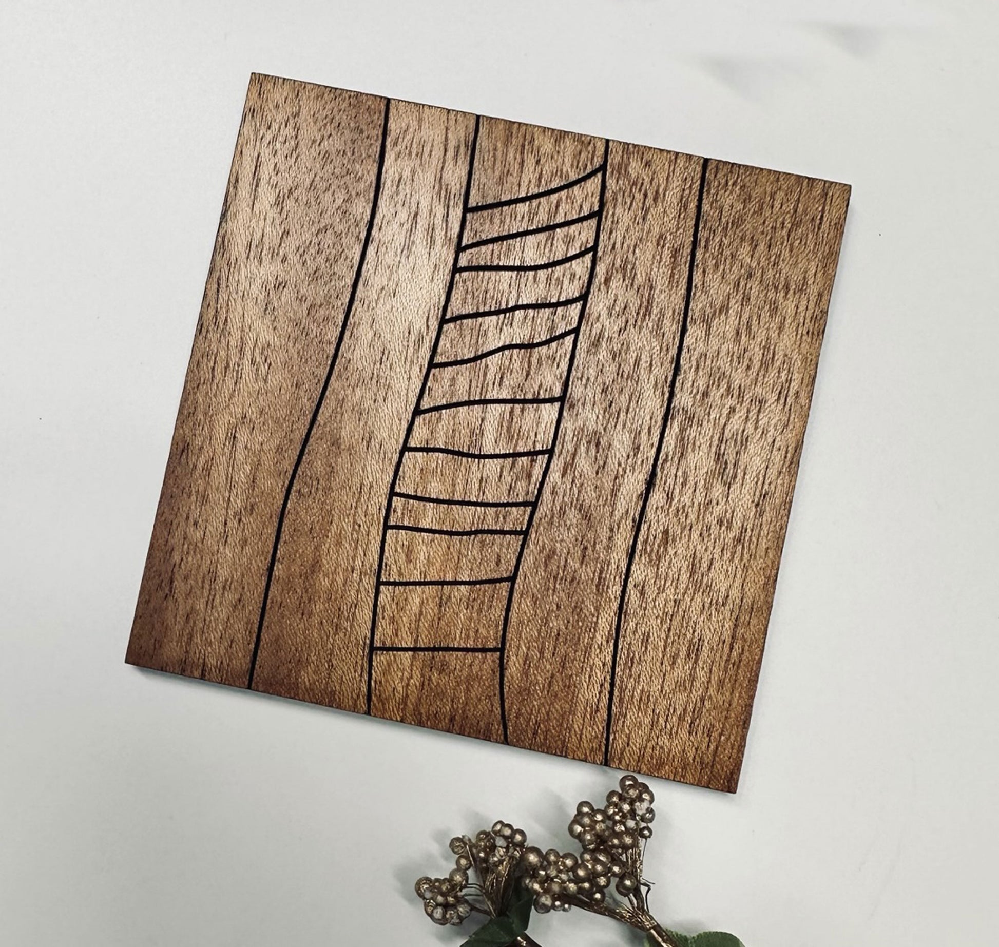 Wooden coaster with leaf design on a white surface