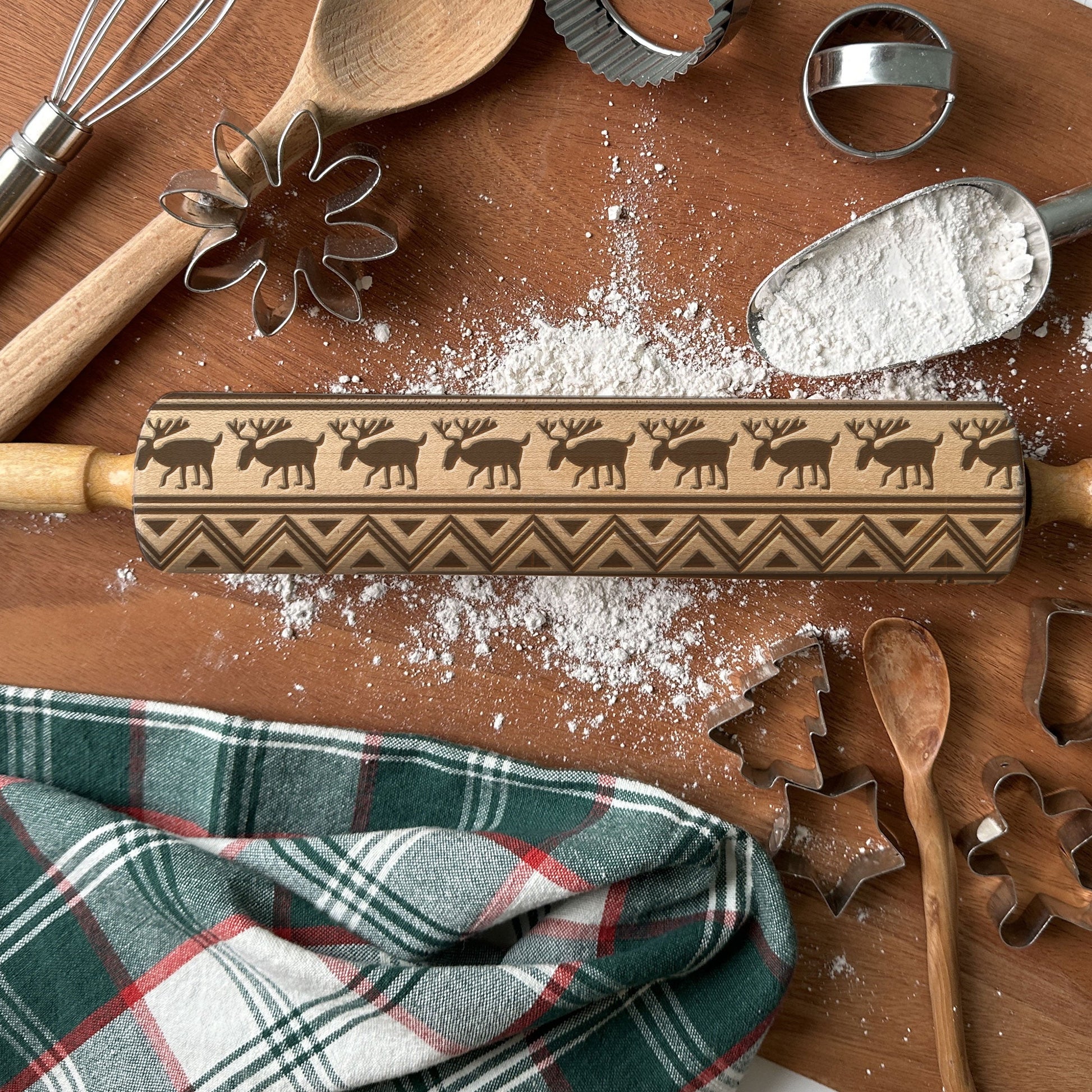Wooden rolling pin with engraved patterns on a wooden surface with baking tools and flour.