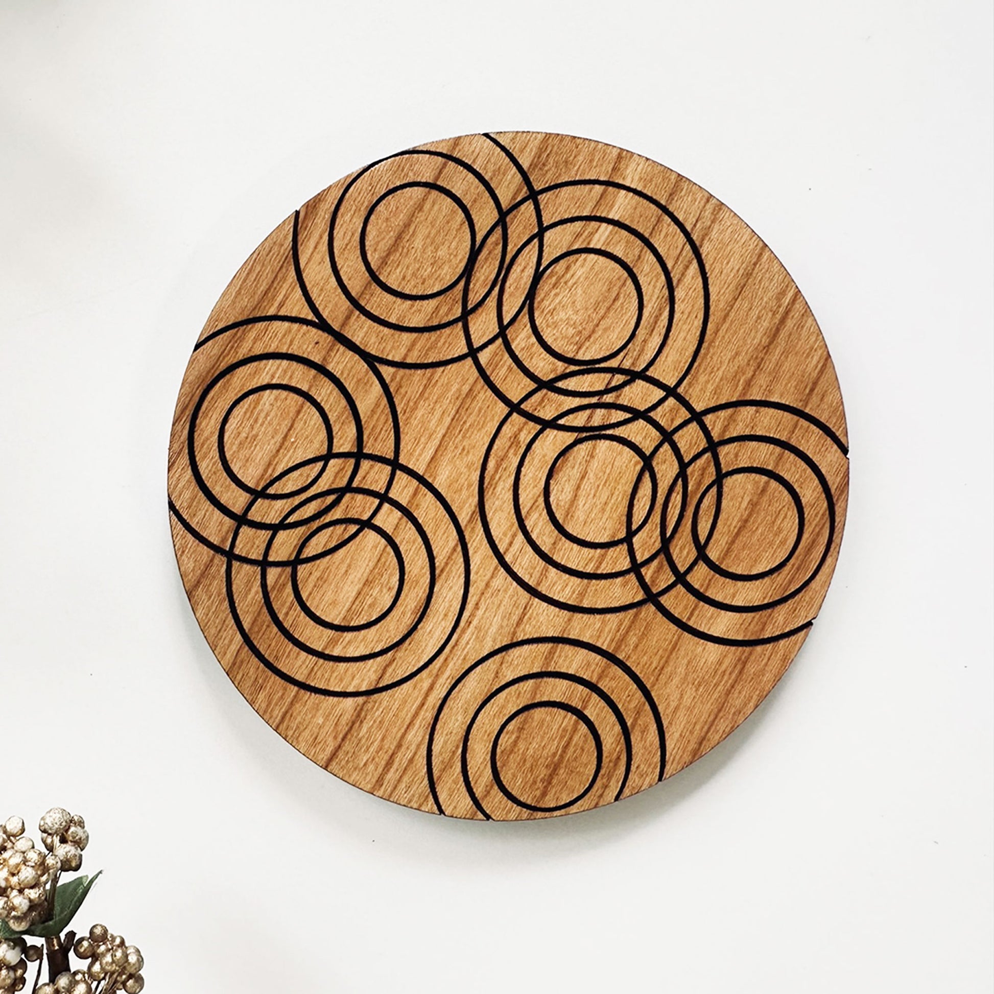 Wooden coaster with circular laser cut design on a white background