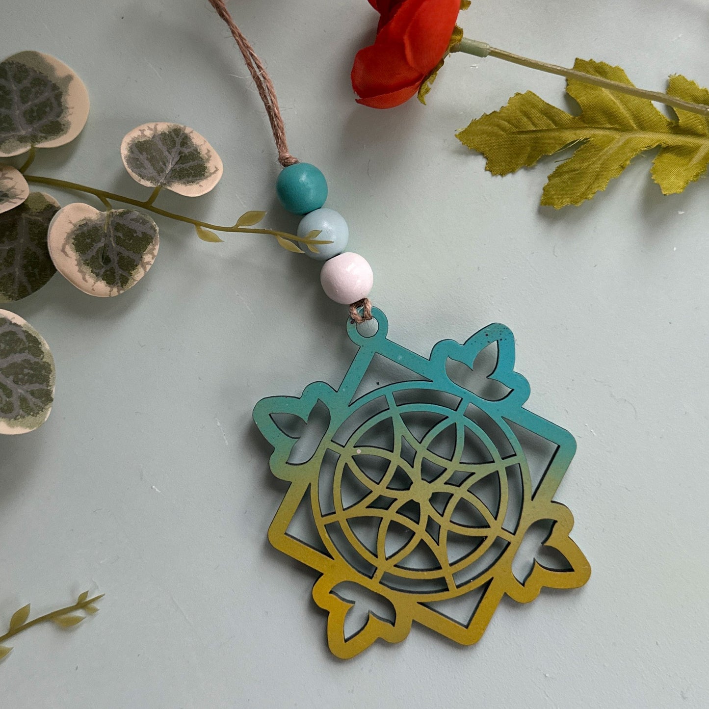 Decorative ornament with beads and a floral arrangement on a light background