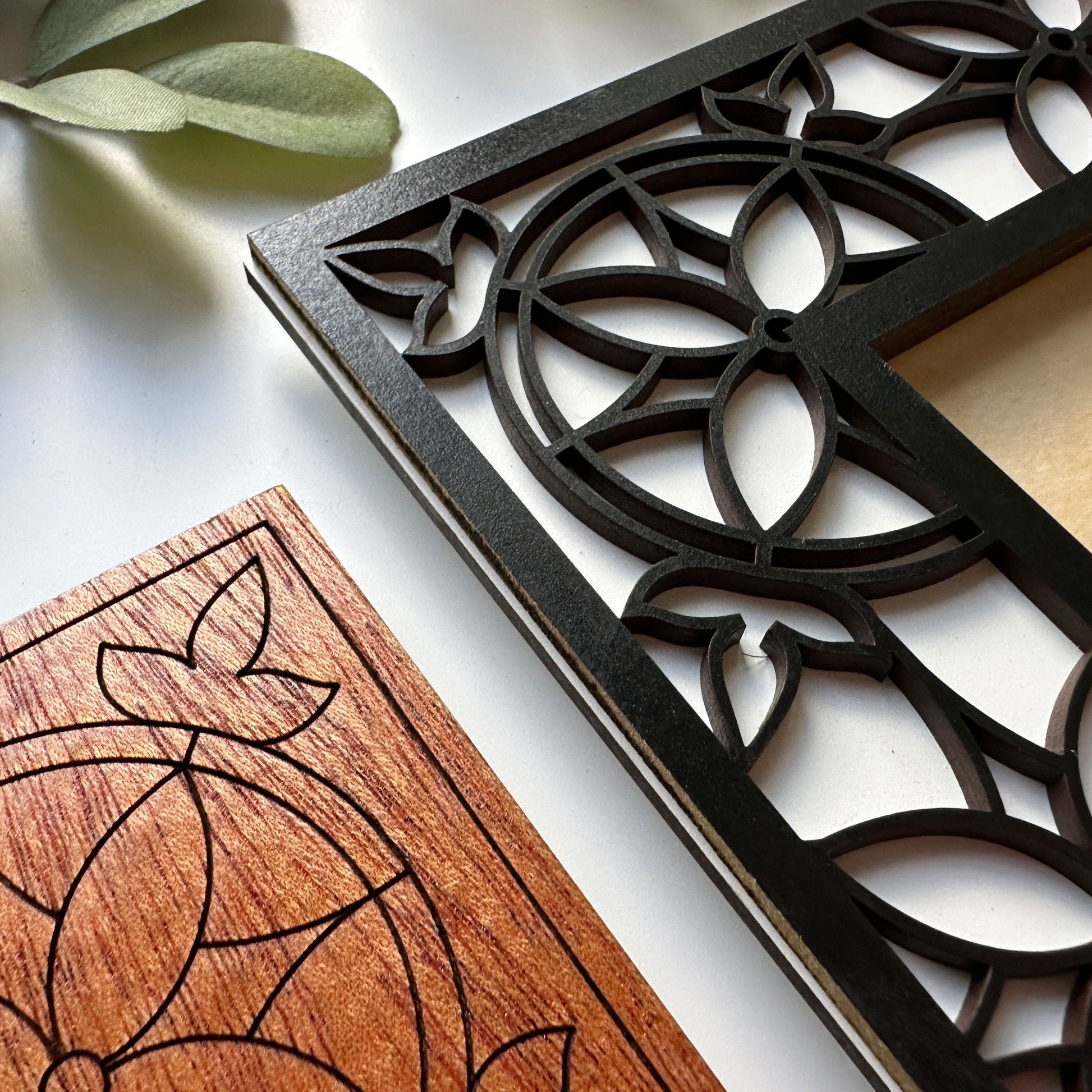 Decorative wooden and metal wall art pieces with intricate patterns on a light background.