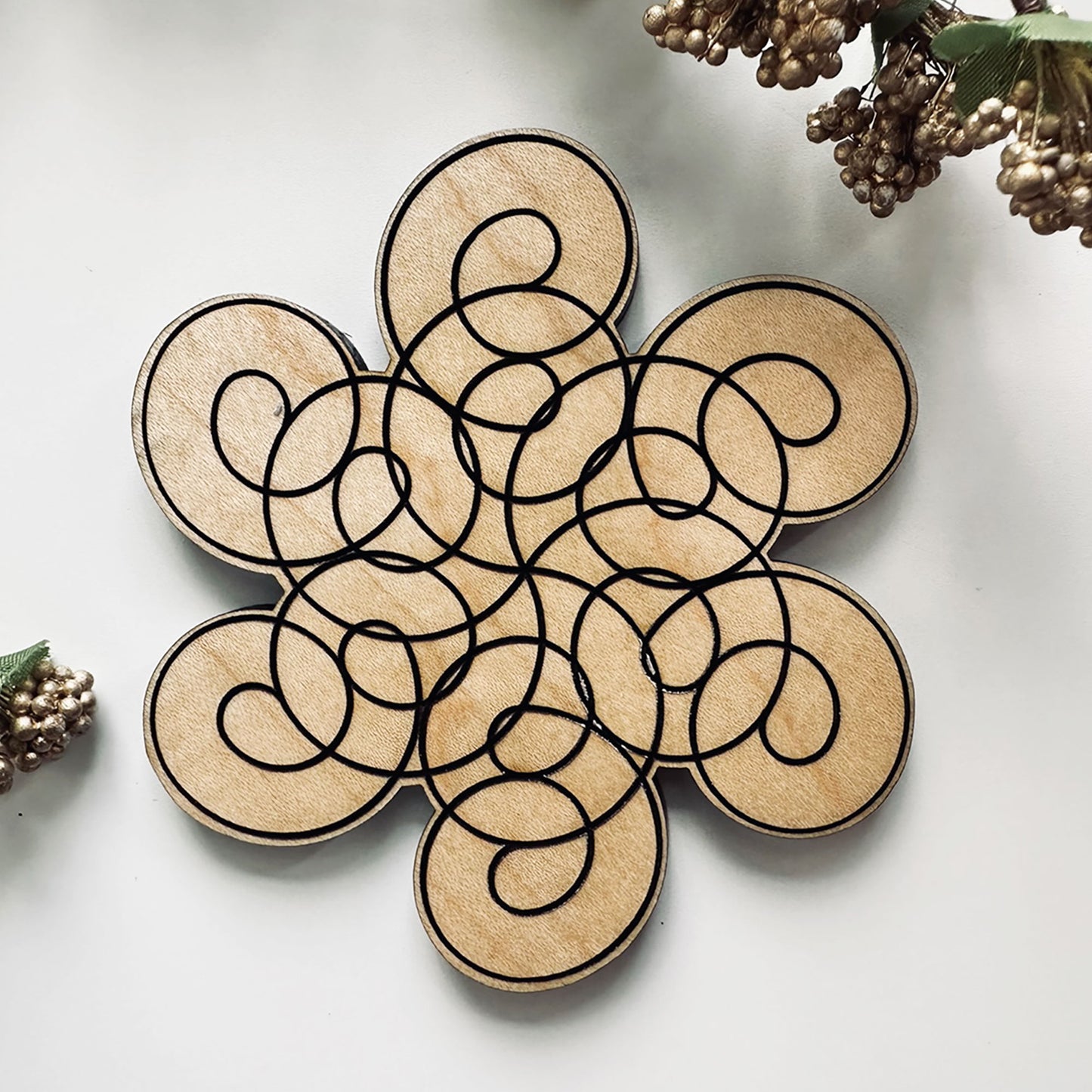 Decorative wooden coaster set with circular design on a light background