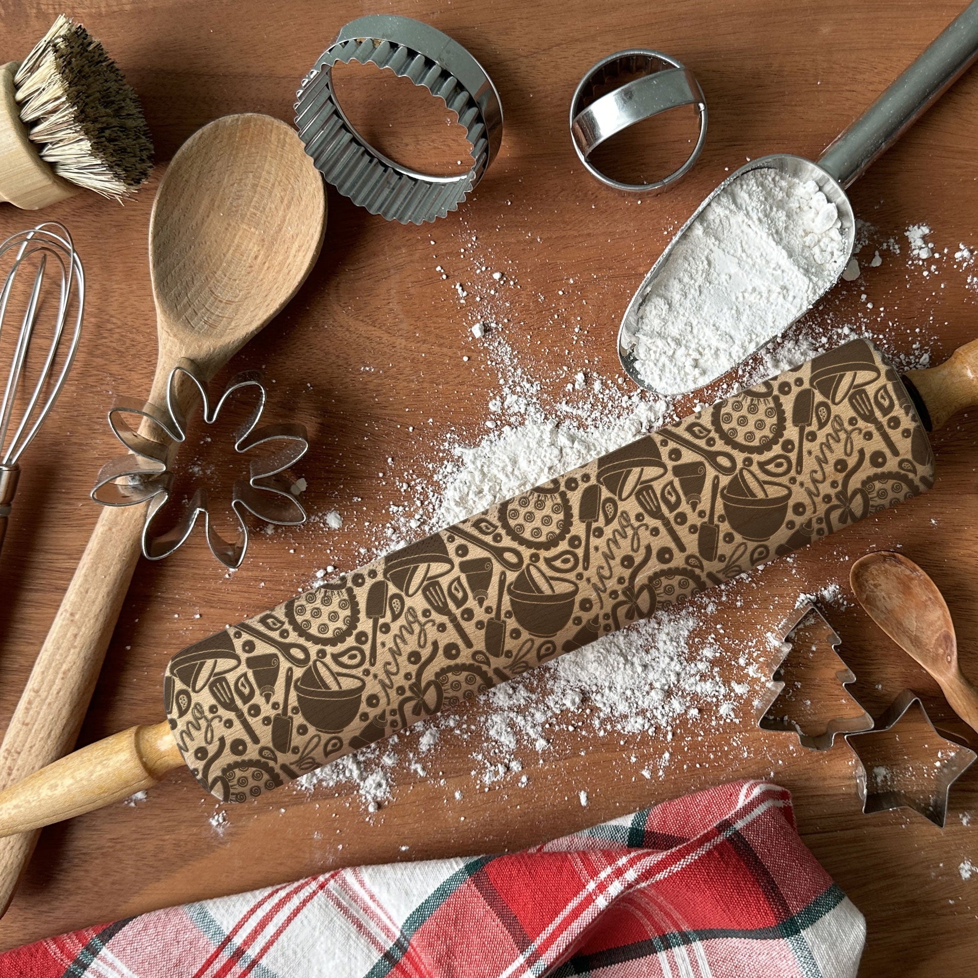Wooden rolling pin with embossed pattern on a wooden surface with baking tools.