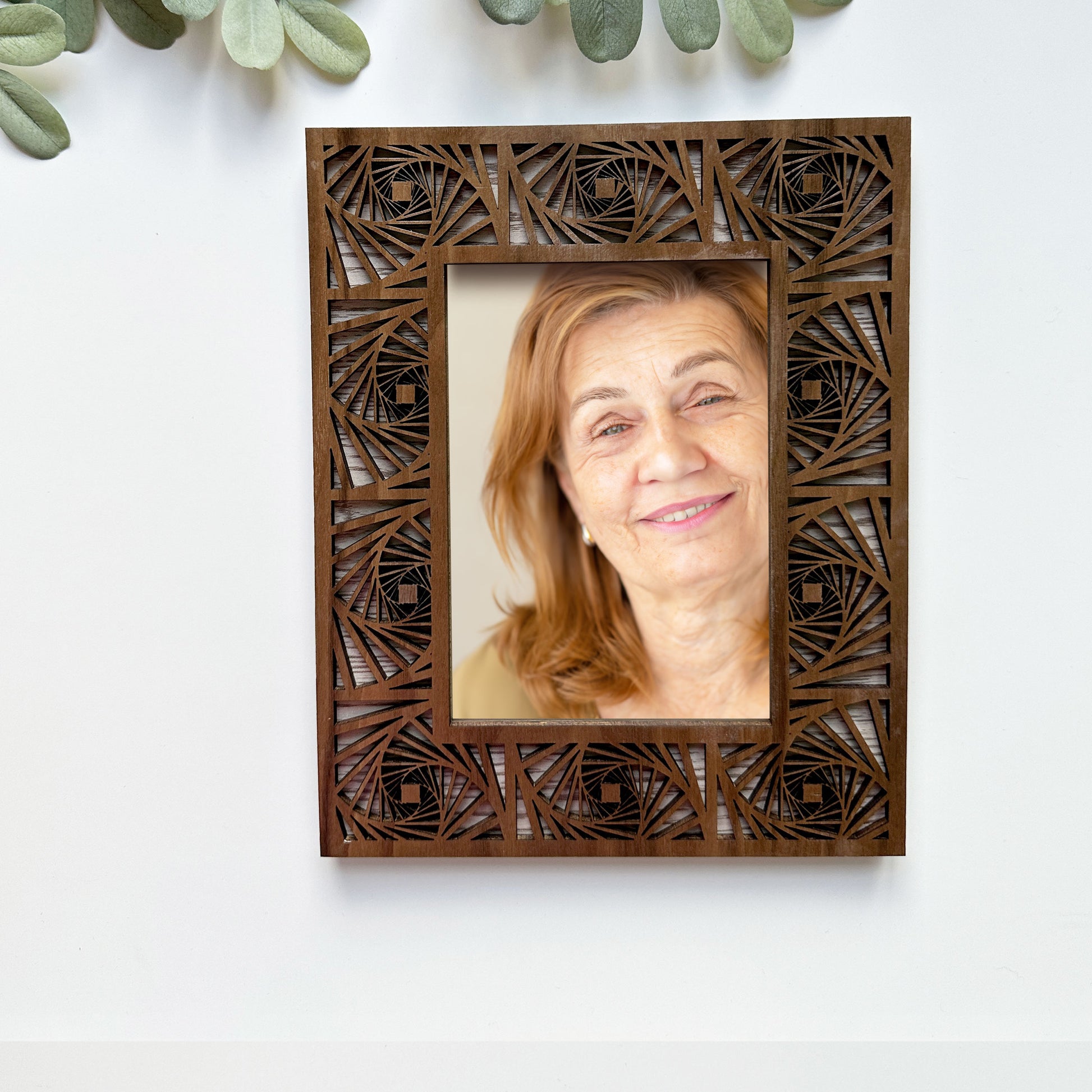 Wooden photo frame with intricate cut-out design on a white background