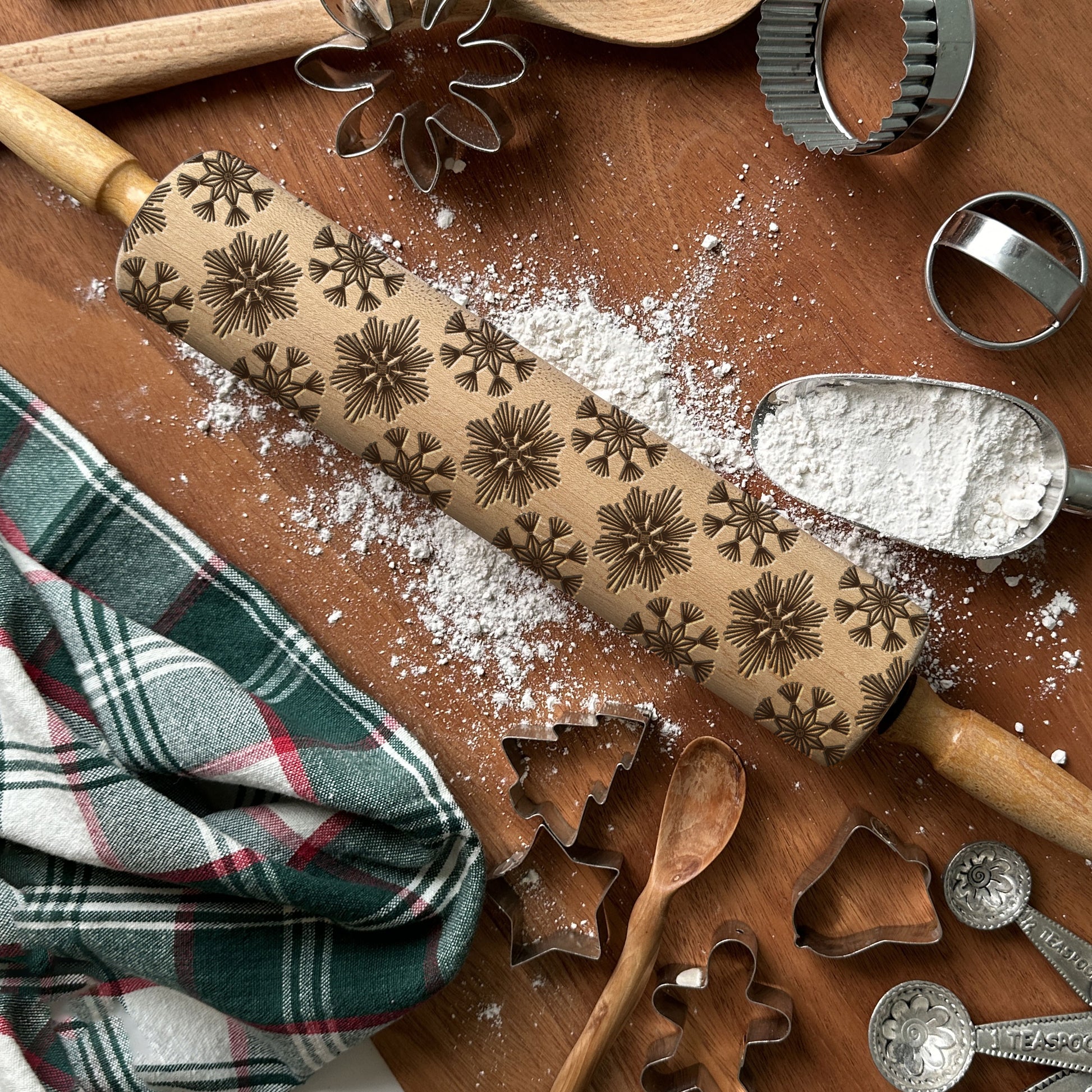 Decorative rolling pin with star patterns on a wooden surface with baking tools.