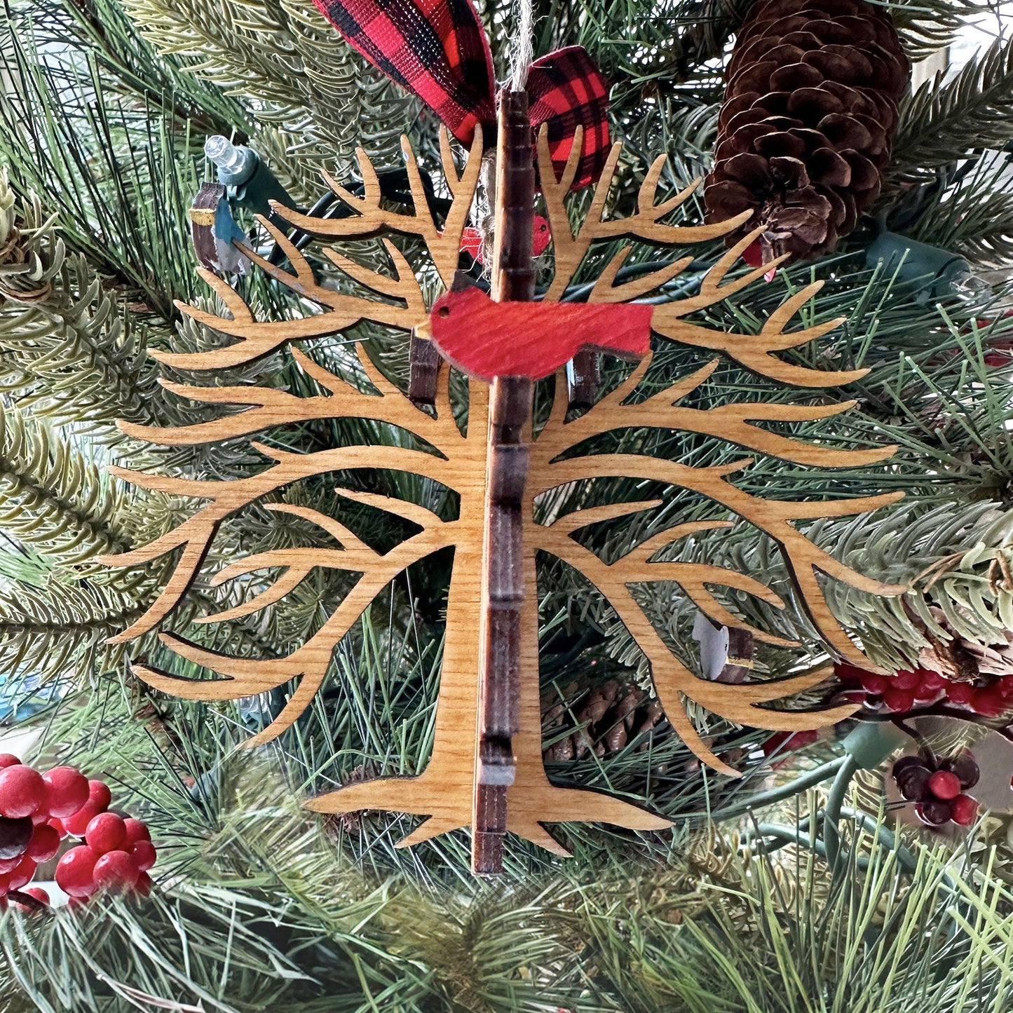 Decorative Christmas tree ornament with red accents hanging on a tree.